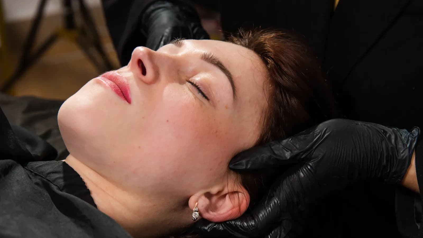 Atendimento de harmonização facial, com luvas de procedimento